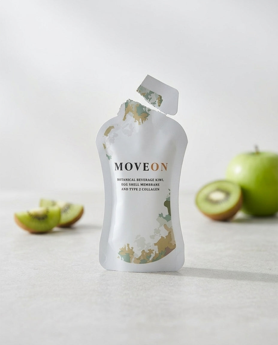 A MoveOn sachet on a sunlit counter beside a glass of its amber-orange juice